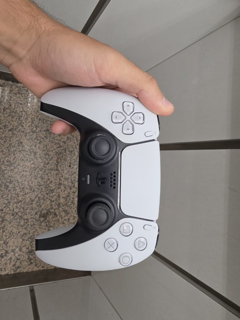 Mando PS5 DualSense blanco sostenido en la mano durante diagnóstico de batería en Reparo Electrónica