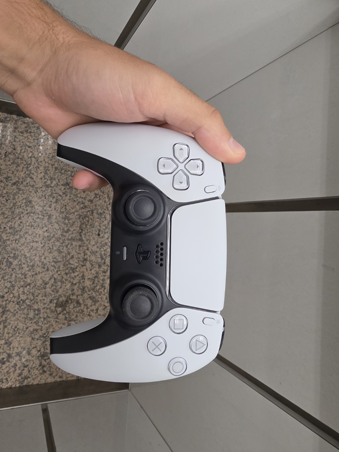 Mando PS5 DualSense blanco sostenido en la mano durante diagnóstico de batería en Reparo Electrónica